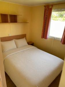 a bedroom with a white bed and a window at Chez Elisa et Fabien in Canet-de-Salars
