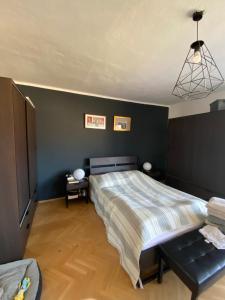 a bedroom with a bed and a black wall at Byt Staré Mesto in Liptovský Mikuláš