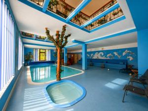 a pool with a palm tree in the middle of a room at Pensiunea Sub Piatră in Sălciua de Sus