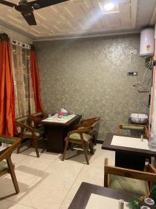 a restaurant with tables and chairs in a room at Vakil Villa in Srinagar