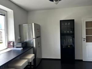a kitchen with a refrigerator and a counter with stools at Byt Staré Mesto in Liptovský Mikuláš