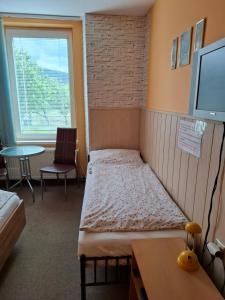 a room with two beds and a table and a window at Privát Čujová in Hrabušice