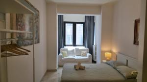a bedroom with a bed and a chair and a window at Piccinni house in Bari
