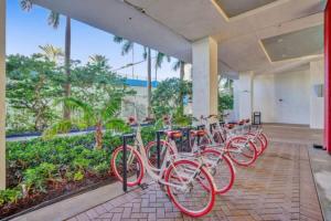 a row of red bikes parked in a building at Ocean & Canal View Studio Beach 8 Min Pool 1906 in Hallandale Beach
