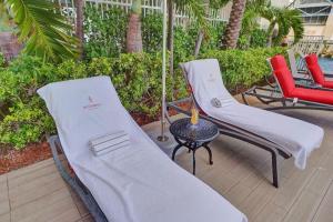 two lounge chairs and a table on a patio at Ocean & Canal View Studio Beach 8 Min Pool 1906 in Hallandale Beach