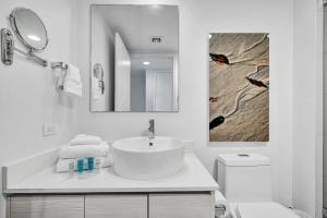 a white bathroom with a sink and a mirror at Ocean & Canal View Studio Beach 8 Min Pool 1906 in Hallandale Beach +34 photos