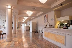 a lobby with columns and a bar in a building at Grand Hotel Forlì in Forlì +125 photos