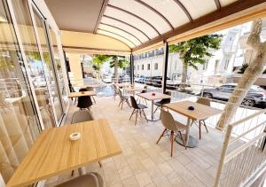 a patio with tables and chairs and a building at Hotel Ariva in Rimini