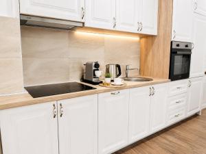 a white kitchen with a sink and a microwave at Swiss Luxury Appartement in Dobra Voda +26 photos