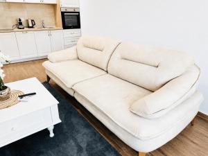 a white couch in a living room with a table at Swiss Luxury Appartement in Dobra Voda