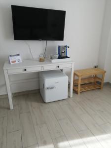a white desk with a television on a wall at Prima Stella Tourist Rooms in Minturno