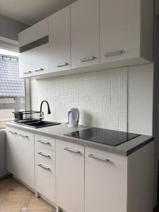 a kitchen with white cabinets and a sink at Horiza in Gdańsk