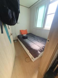 a small bed in a room with a window at 1room 1bed Gangnam in Samgong