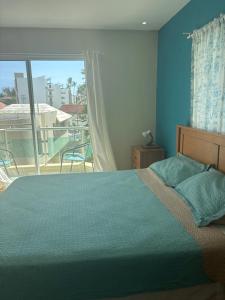 a bedroom with a bed and a large window at Yara Beach in Punta Cana