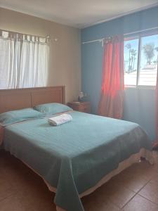 a bedroom with a bed with a green blanket and a window at Yara Beach in Punta Cana