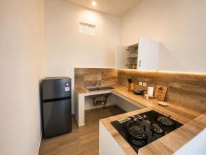 a kitchen with a black refrigerator and a sink at The Kubu Sidemen 2 in Silebeng +15 photos