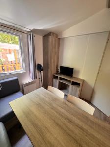a room with a table and a desk with a laptop at Camping les sablons in Vergeroux