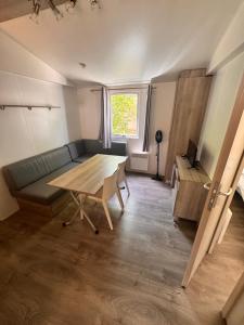 a living room with a table and a couch at Camping les sablons in Vergeroux +7 photos