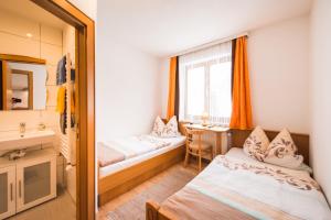 a hotel room with two beds and a desk at Hotel Pension Barbara in Sankt Martin am Tennengebirge