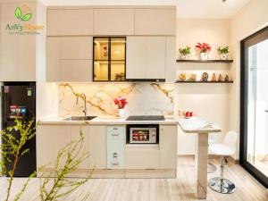 a white kitchen with a counter and a table at AnVy house Skyforest 2 Ecopark in Xuân Quan