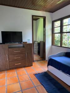 a bedroom with a bed and a flat screen tv at Pousada do Pescador in Florianópolis