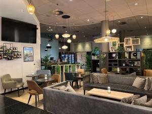 a restaurant with a couch and tables and chairs at ibis Hotel Brussels Centre Gare du Midi in Brussels