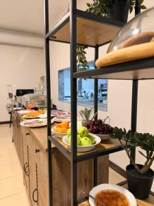 Eine Küche mit Tellern voller Obst und Gemüse in Regalen in der Unterkunft Sheldon Hotel in Yerevan