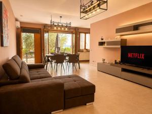 a living room with a couch and a tv and a table at La Perla in Passignano sul Trasimeno