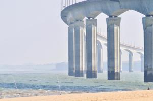 a bridge over the water next to a beach at Fleur de Ré in Loix