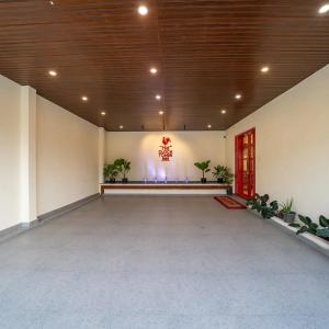 a large empty room with a red door and plants at The Clock Tower Inn in Bangalore
