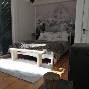 a bedroom with a bed with a bench on it at Cabaña sobre el Lago Cholila in Cholila