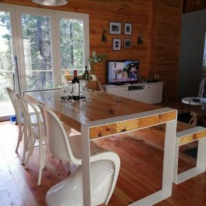 a dining room with a wooden table and chairs at Cabaña sobre el Lago Cholila in Cholila