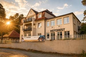 a large white building with the sun in the background at Pokoje Pasáž in Doksy +9 photos