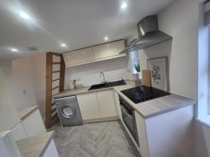 a kitchen with a sink and a washing machine at The Loft Studio Westbury in Westbury +15 photos