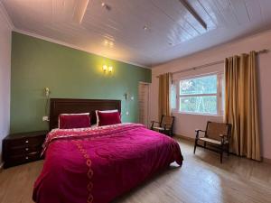 a bedroom with a large bed with a pink blanket at Haven Daisy Meadows - 2BR Cottage with Lawn in Changla Gali in Chhāngla Gali