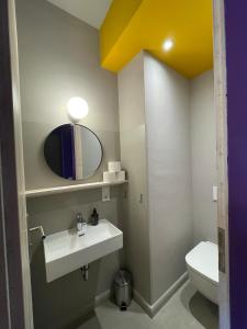 a bathroom with a sink and a mirror and a toilet at Farbenfrohes Appartment in Wittenberge in Wittenberge