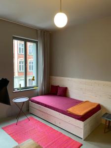 a bedroom with a bed with pink sheets and a window at Farbenfrohes Appartment in Wittenberge in Wittenberge