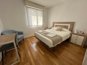 a bedroom with a bed and a desk and a window at Candle Home Sáenz Díez in Ourense