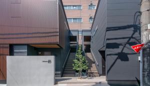 a building with stairs and a tree in front of it at T-home彩 in Tokyo