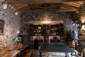 a ping pong table in a room with stone walls at Casa Do Populo in Ponta Delgada