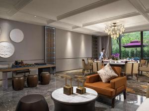 a lobby of a hotel with a table and chairs at Pullman Yuxi in Yuxi