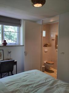 a bedroom with a bed and a bathroom with a toilet at HotelPension van Ewijcksluis in Anna Paulowna +75 photos