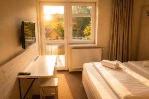 a hotel room with a bed and a window at Pokoje Pasáž in Doksy