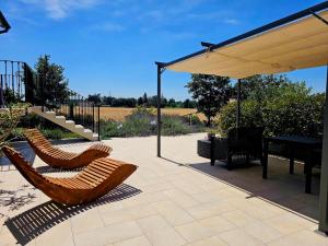a patio with two chairs and a table and an umbrella at Chicche di Lavanda in Valmadonna +11 photos