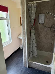 a shower with a shower curtain in a bathroom at The Burlington Hotel in Torquay +23 photos
