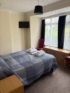 a hotel room with a bed and a desk and window at The Burlington Hotel in Torquay
