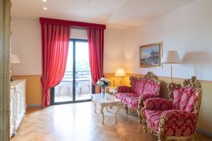 a living room with two chairs and a table at Grand Hotel Forlì in Forlì