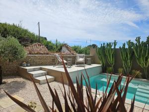 a backyard with a pool with a table and a chair at Viladraga - Casa da Ursa in Colares