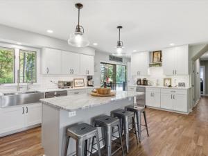 a kitchen with white cabinets and a large island with bar stools at Oyster Haven in Cambridge