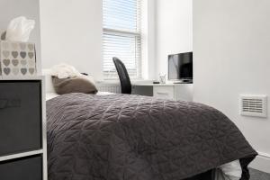 a bedroom with a bed and a desk and a television at Cinderhouse Highbury Vale in Nottingham